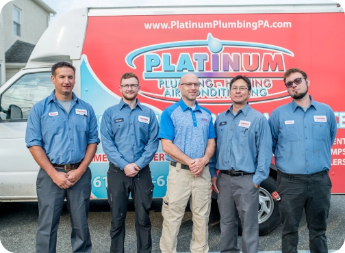 Five men in uniform stand proudly in front of the Platinum Plumbing and Heating truck. Dressed in blue shirts with name tags, they represent the expertise and professionalism that defines Platinum Plumbing’s commitment to quality service.