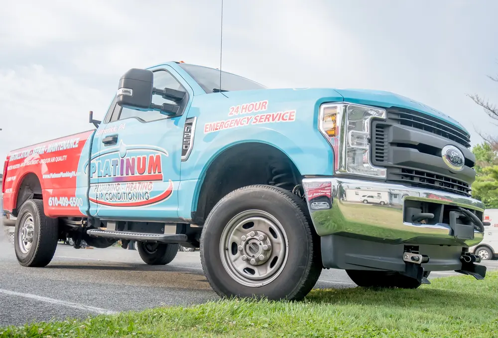 Blue and red service truck with "Platinum Heating & Air Conditioning" and "24 Hour Emergency Service" logos, parked on a road. Join our team—exciting careers available now!.
